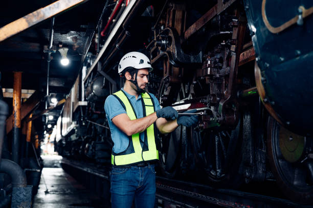 istock Engineer railway wearing safety uniform and helmet under checking under train ,wheels and control system for safety travel passenger. 1555115384