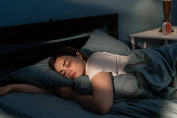 jovem fêmea dormindo tranquilamente em seu quarto à noite. relaxando à noite - boa noite - fotografias e filmes do acervo