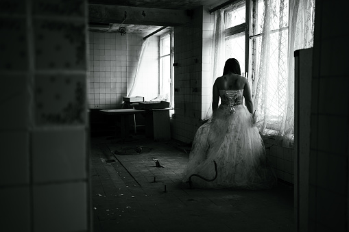 Horror night,ghost of bride in haunted house,mysterious woman in white dress standing in abandoned building. Copy space