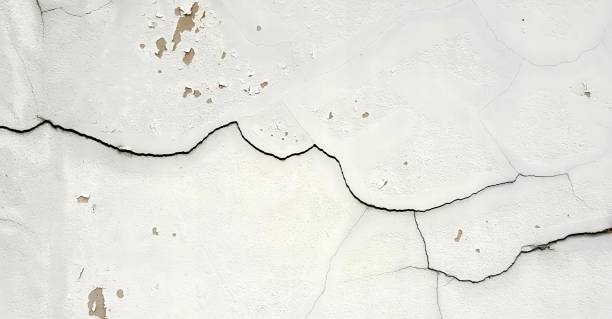 istock a photography of a white wall with cracks and a black fire hydrant, white paint on a wall with a crack in it. 1555117831