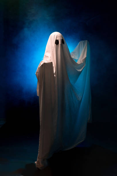 istock Ghost in a sheet on a black background in smoke 1555121309