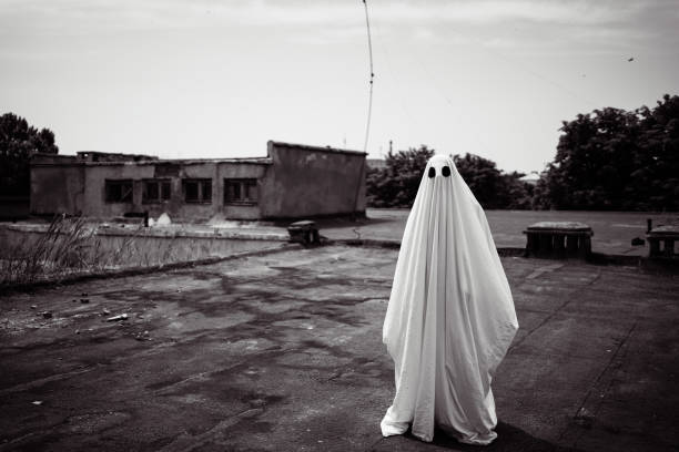 Mystery, magic, Halloween concept. Ghost covered with a white ghost sheet on roof in abandoned house. vintage look.