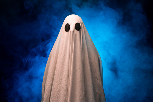 White Ghost on Black Background in the fog. Halloween concept. Copy space