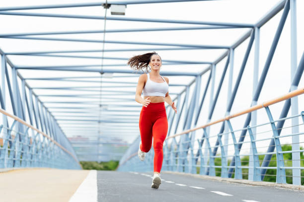 istock Young woman running outdoors on the bridge 1555151125