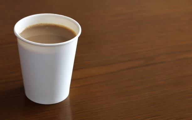 istock A recycled paper cup with a latte on a wooden table. Space for text. 1555152219