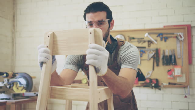 Handsome Professional carpenter Working in a Studio.
