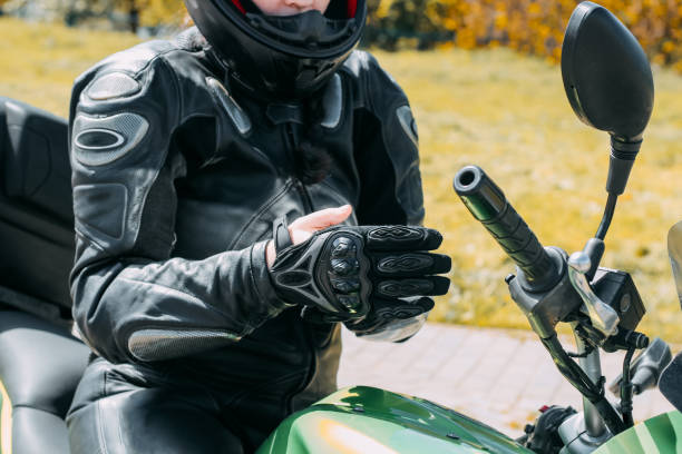 istock A girl in a motorcycle protective helmet puts on gloves 1555159764