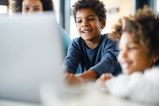istock Happy African American boy using laptop at home. 1555178742