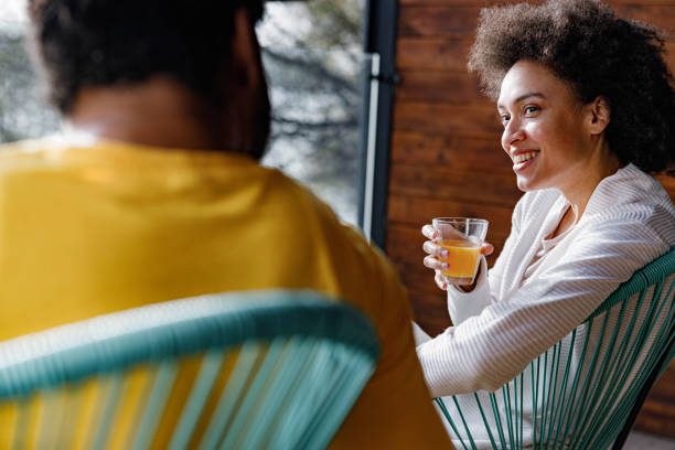 istock Happy black couple talking while relaxing at home. 1555183690