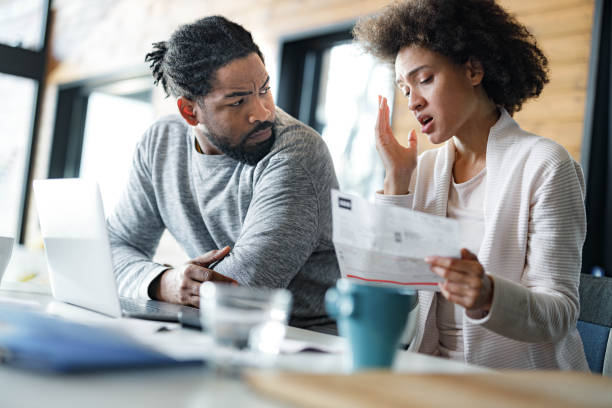 istock Young black couple having problems with online banking at home. 1555185872