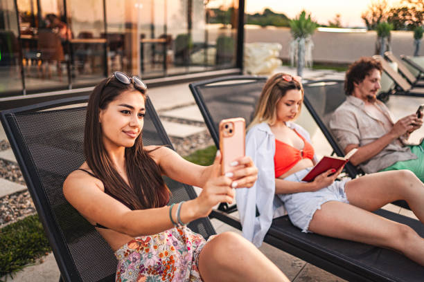 istock Three friends laying down on sunbeds, relaxing by the swimming pool 1555185899