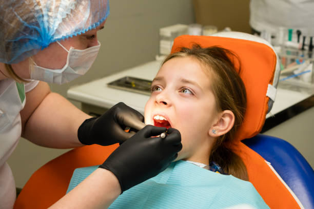 istock Girl on dental appointment. Regular check up teeth 1555185951