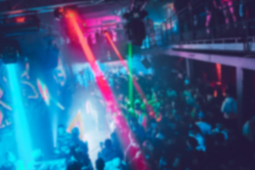 Blurred background of people dancing on a dance floor. Concept of nightlife, clubs, party