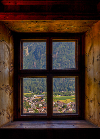 old window with the dolomites in the background