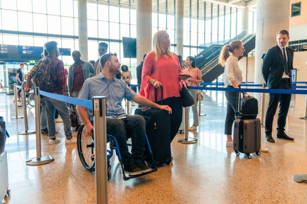 disabled caucasian male in a check in line at the airport lobby - airport arrival departure board airport check in counter airplane imagens e fotografias de stock
