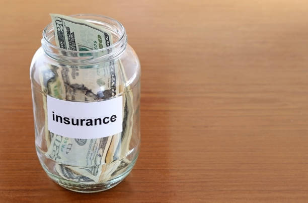 istock Glass jar with savings or tips to pay for care insurance. Space for text 1555226003