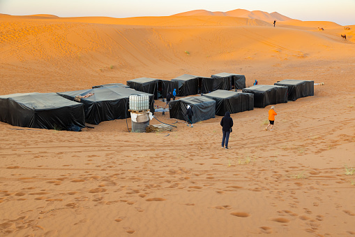 Tourists at tent camp in desert, Merzouga, Erg Chebbi sand dunes region, Sahara, Morocco. Model released.