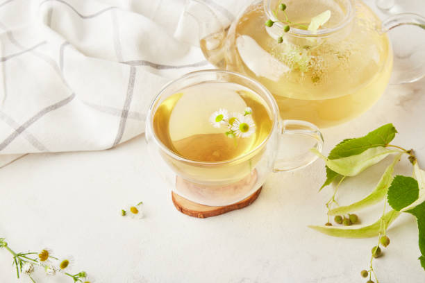 istock Healthy natural organic linden and chamomile tea blossoms. Summer table setting, natural beverage, benefits and properties concept 1555237224