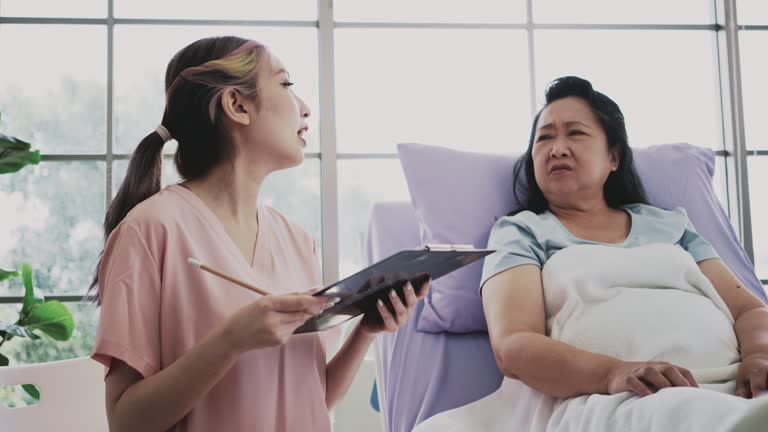 Friendly nurse talking with hospital patient