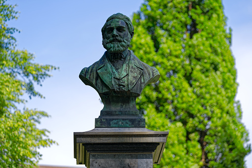 Close-up of bronze memorial bust of Wilhelm Baumgartner 1820–1867 at Platzspitz Park at Swiss City of Zürich on a sunny hot summer day. Photo taken July 18th, 2023, Zurich, Switzerland.