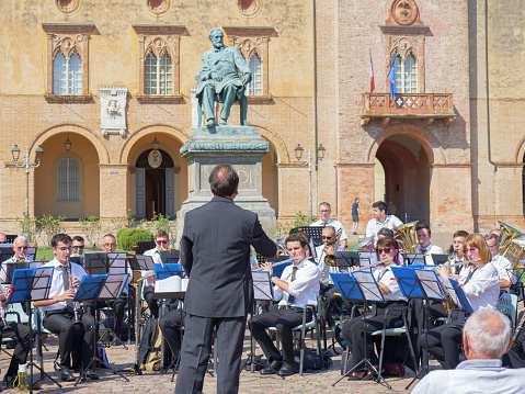 Parma, Italy - september 2022: Orchestra Performing Outdoors right in Front of Rocca Pallavicino and the Statue of Giuseppe Verdi, Italian Composer, Parma, Italy.