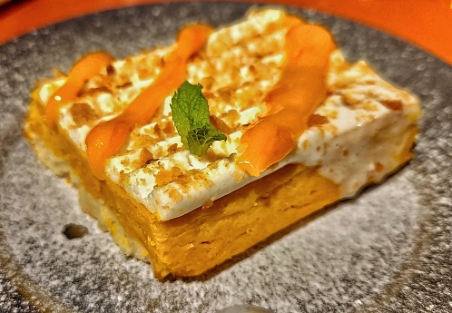 Sweet cake with coconut creme, nut and  papaya topping.