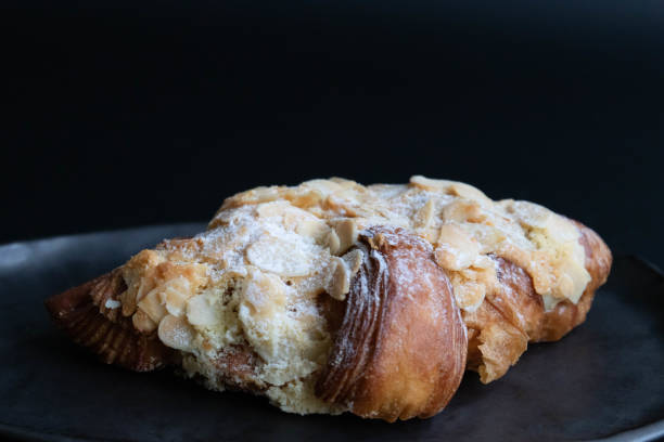 istock Close up Almond Croissant on Black background 1555306692