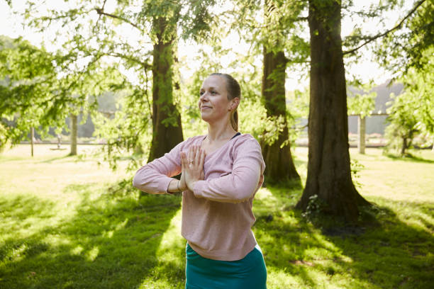 istock Woman doing yoga in park 1555308323