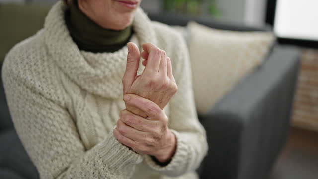 Mature hispanic woman with wrist pain at home