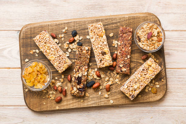 istock Various granola bars on table background. Cereal granola bars. Superfood breakfast bars with oats, nuts and berries, close up. Superfood concept 1555329013
