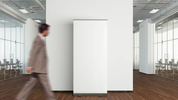 istock Blank roll up banner stand mock up in modern office. 1555352070