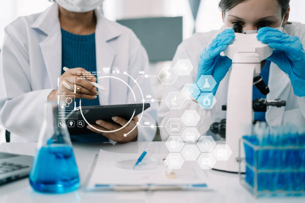 istock Team of biochemical research scientists working with a microscope for vaccine development in pharmaceutical research labeling. 1555354839