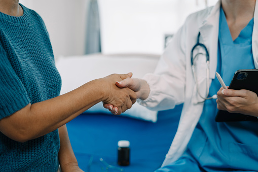 Female doctors shake hands with patients encouraging each other. To offer love, concern, and encouragement while checking the patient's health. concept of medicine.