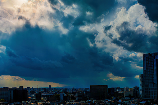 Image of sky, clouds, city and buildings, stormy daytime