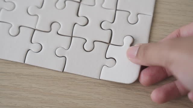 Hands solve to compete the jigsaw puzzle. Unity, teamwork, business organization and planning concept