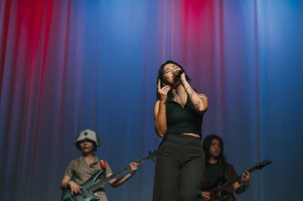 Young Asian chinese lead singer and live band Multiracial group performance on stage stock photo