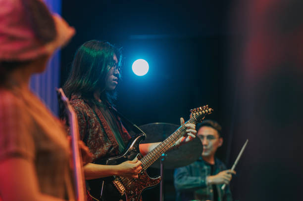 istock Young guitarist jam session at Asian Multiracial group live band performance on stage 1555389886