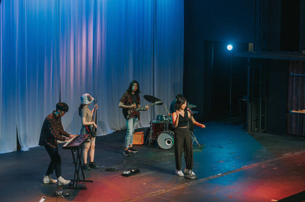 istock Young Asian Multiracial group female lead singer live band performance on stage 1555390434