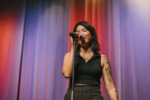istock young asian chinese Solo female singer singing performance on stage 1555390440