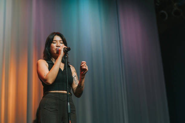 istock young asian chinese Solo female singer singing performance on stage 1555390448