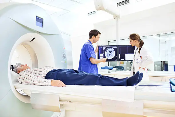 Patient, Doctor and medical technician at the computer tomography getting a scan