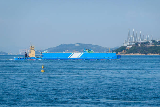 "Pusher Barge", a working boat that crosses the Seto Ohashi Bridge (Sakaide City, Kagawa Prefecture) On a sunny day in March 2023, at the Seto Ohashi Memorial Park at the northern end of the Bannoshu industrial area in Sakaide City, Kagawa Prefecture, a working ship "Pusher Barge" crosses the Seto Ohashi Bridge. 押す stock pictures, royalty-free photos & images