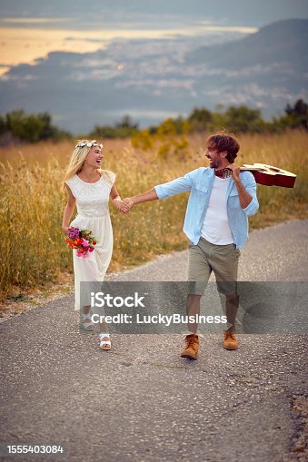istock Happy newlyweds walking the road in the nature. Relationship, honeymoon, nature 1555403084
