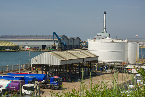 Fuel distribution depot at Shoreham Port in West Sussex, England. With power station and warehouses with solar panels on roof in background.