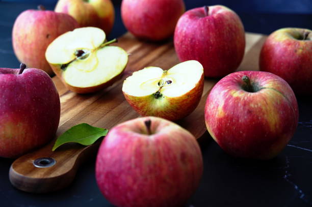 istock Red apples on wooden cutting board 1555421078