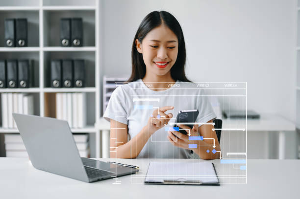 istock Project manager working and update tasks with milestones progress planning and Gantt chart scheduling diagram. business working with smart phone, tablet and laptop in office. 1555433013