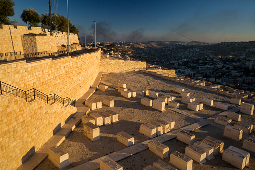Horizontal high angle view of the smoke on Gaza Strip from the Mount of Olives Jewish Cemetery in Jerusalem