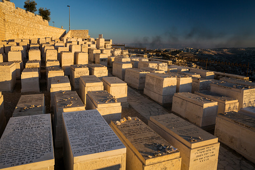 Panoramic view of the Mount of Olives Jewish Cemetery with the smoke on Gaza Strip in the background in Jerusalem