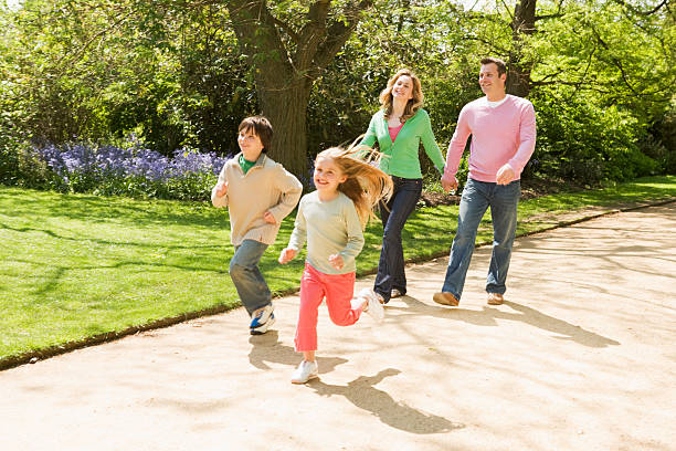 istock Family running on path holding hands smiling 155544378