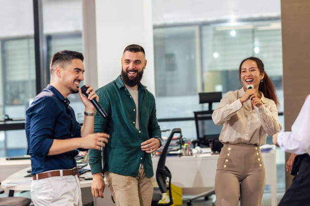 istock Group of professional people singing karaoke in the modern office 1555455911